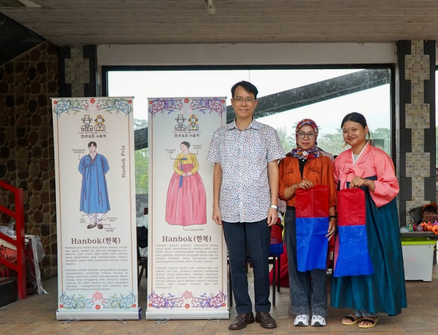 Direktur KCCI Kim Yong Woon berfoto bersama di depan banner pakaian tradisional Korea, Hanbok.